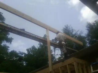 Carpenter setting a ridge beam over a new addition frame — Ice Dam Removal by Roofing Brothers in Ebensburg