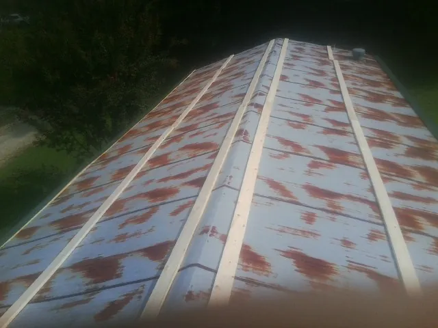 Rusted metal roof panels with new wood purlins before replacement — Storm Damage Roof Repair in Ebensburg by Roofing Brothers