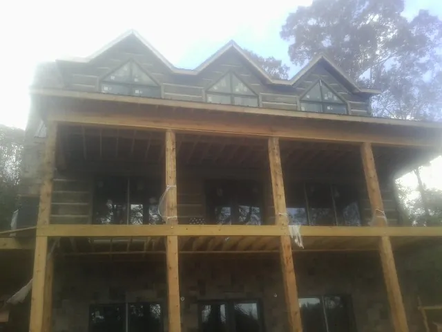 Dormers and porch framing on a large log home under construction — Roof Coating work by our crew in Ebensburg