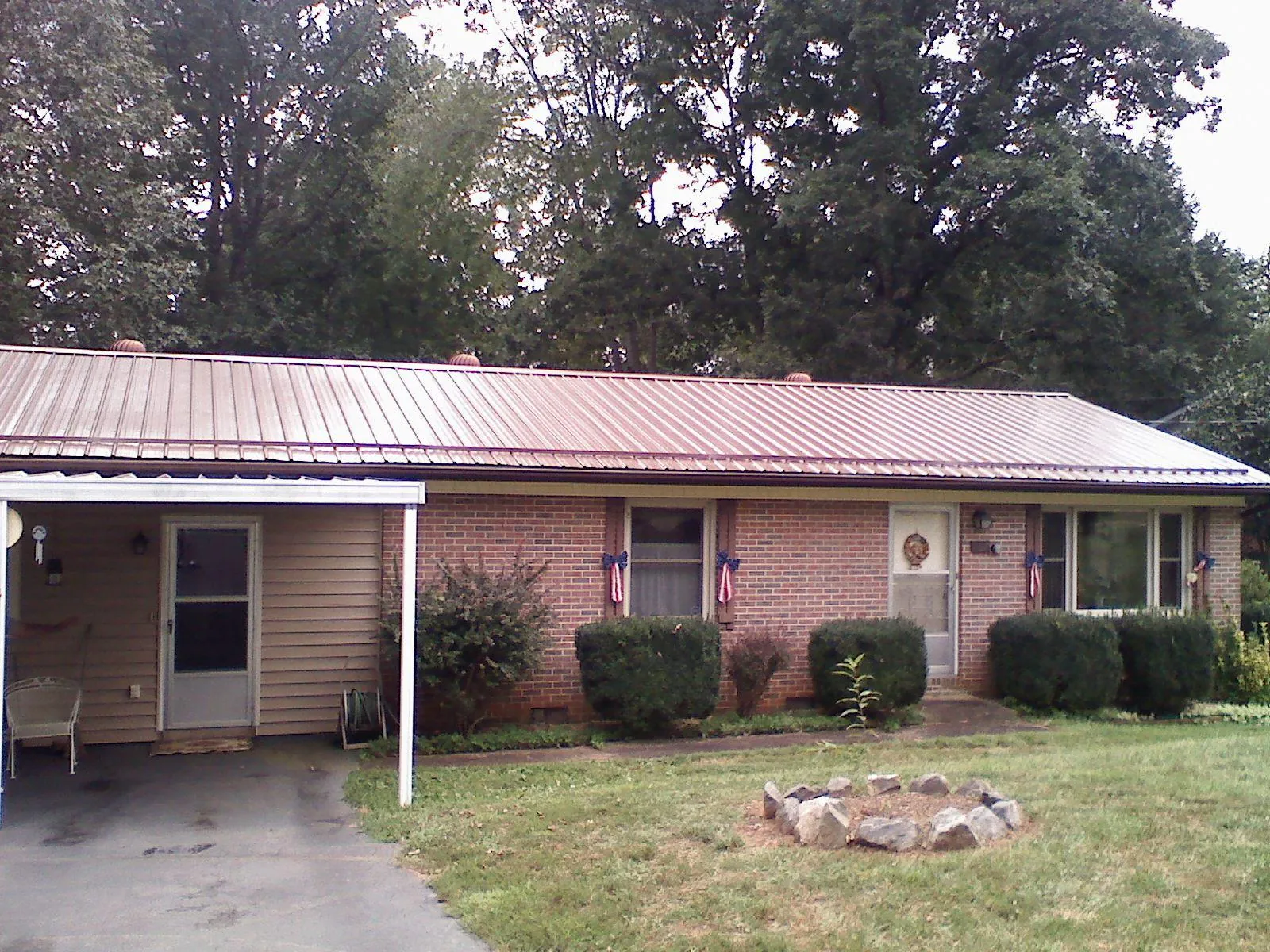 Bronze metal roof and carport on a brick ranch home — Roof Repair work by our crew in Ebensburg