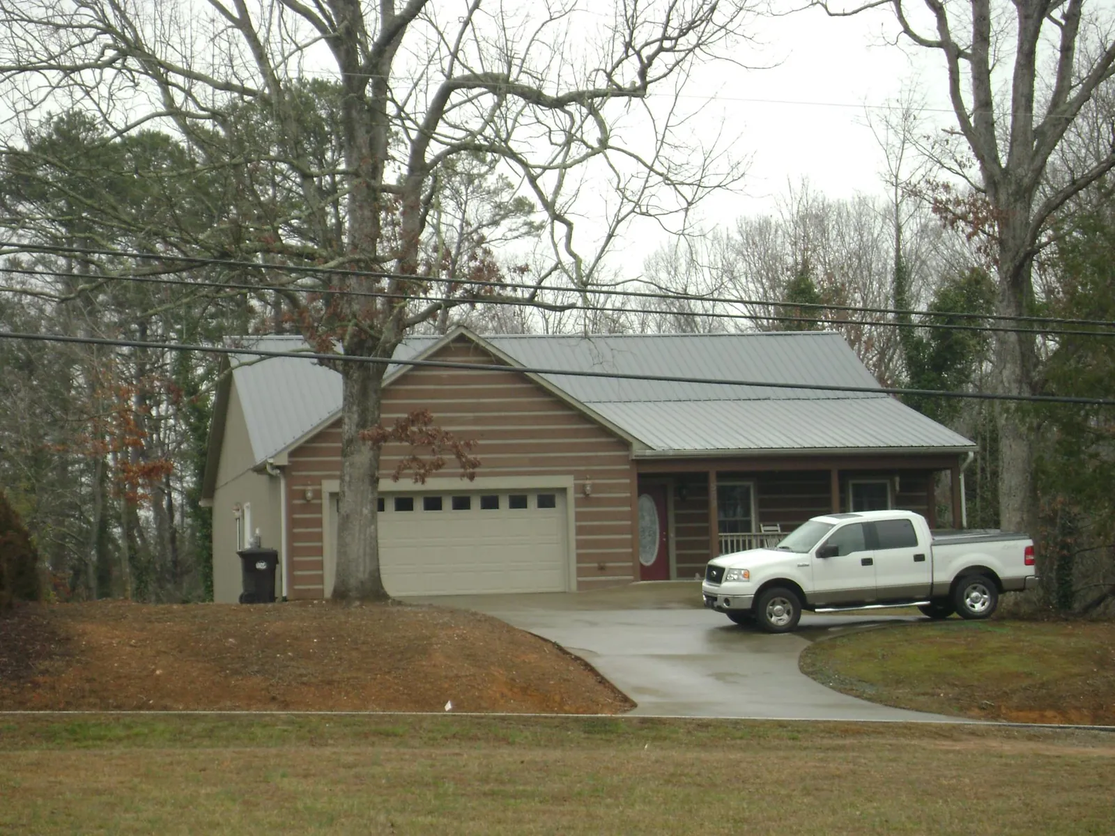 Gray metal roof on a log sided house with an attached two car garage in Ebensburg